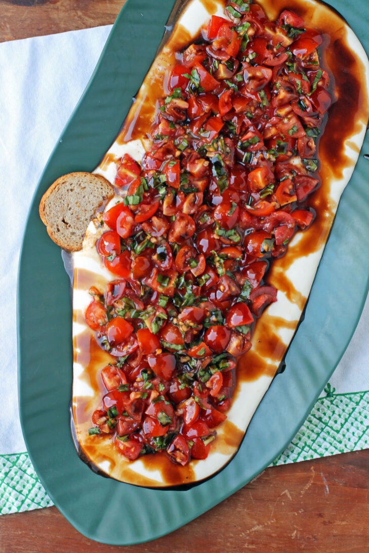 Whipped Feta Bruschetta Dip on a plater with a toast dipped in