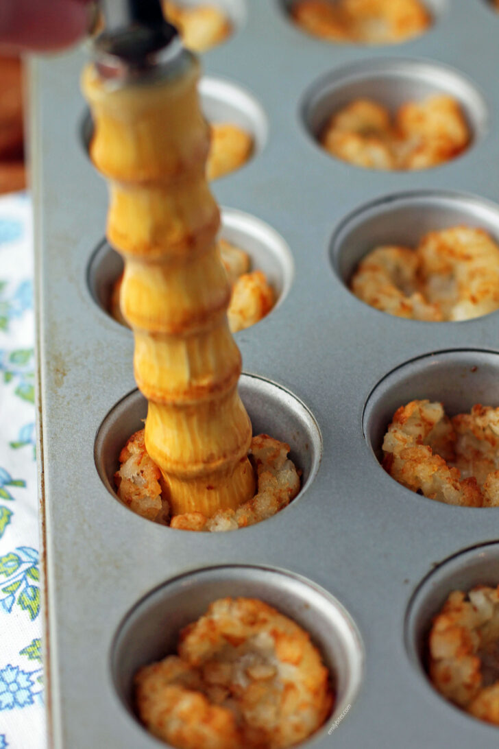 Pressing down the tots to make cups