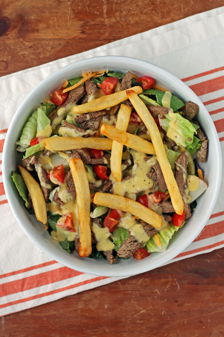Pittsburgh Steak Salad with Warm Riviera Dressing mixed in a bowl